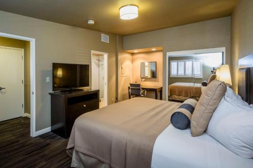 萨克拉门托Lions Gate Hotel的配有一张床和一台平面电视的酒店客房