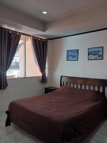乔木提恩海滩Kalisa House@Soi welcome的一间卧室设有一张大床和一个窗户。