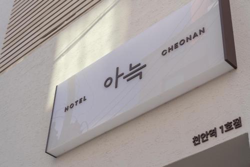 天安市Aank Hotel Cheonan Station 1的建筑物一侧的标志