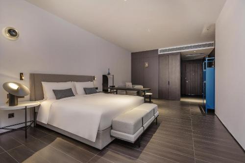 深圳深圳南山科技园HUA华酒店的卧室配有一张白色的大床和一张桌子
