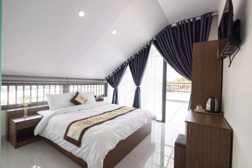 阿普达城Happy Home Da Lat的一间卧室设有一张床和一个大窗户