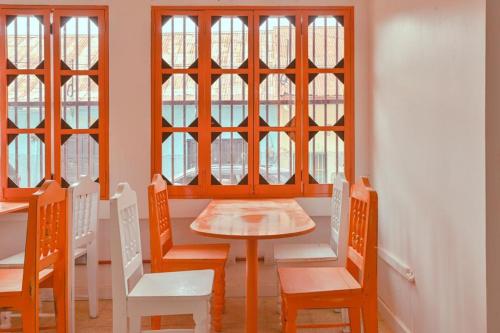 弗洛勒斯Macarena Hostel的一间带桌椅和窗户的用餐室
