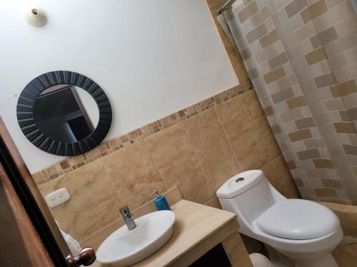 IztapaCasa en condominio monterrico的一间带卫生间、水槽和镜子的浴室