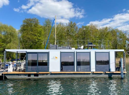 巴特萨罗皮斯库夫TRAUMZEITBOOT auf dem Scharmützelsee Bad Saarow的船停靠在水面上的码头