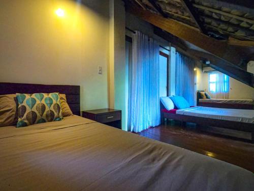 利帕玫瑰别墅度假酒店的一间卧室配有一张床、一张沙发和一个窗口