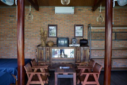 波来古市Homestay Hơ Đơng的客厅配有电视和桌椅