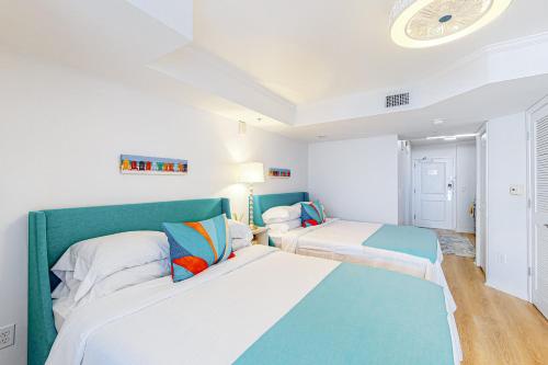 默特尔比奇Club Wyndham 521的白色和蓝色的客房内的两张床