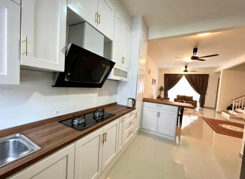 Kampong ChinchangHomestay Ika KLIA @ Enstek的厨房配有白色橱柜,墙上设有电视