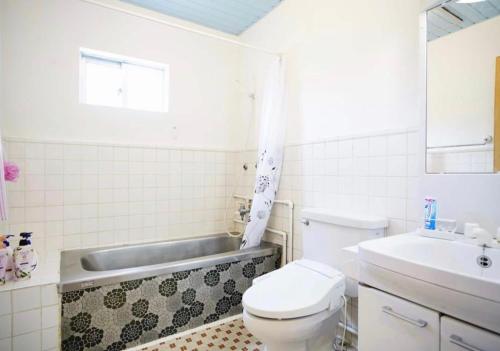嘉手纳Happy House的浴室配有卫生间、盥洗盆和浴缸。