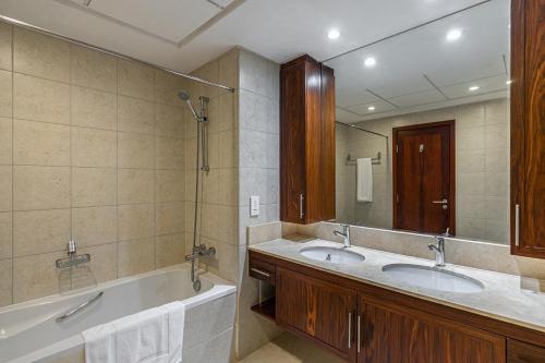 迪拜Splendid Apartments with Burj Khalifa and Fountain View的一间带两个盥洗盆和大镜子的浴室