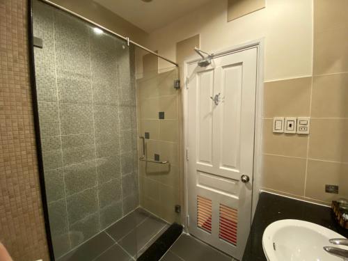 胡志明市Phú Gia Hotel的浴室设有玻璃门和水槽。