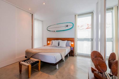 圣何塞德萨塔莱阿SURF HOUSE的卧室配有一张床铺,墙上设有冲浪板