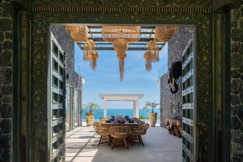 苏梅岛BLUE ELEPHANT Luxury Pool Villa Koh Samui by Blue Mountain Villas的一间带桌椅和吊灯的用餐室