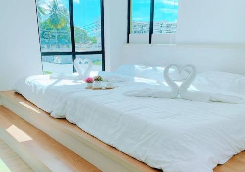 邦咯Pangkor Better Life Cozy Studio-walking 2min to beach,1-4pax的一张白色的床,上面有两个天鹅