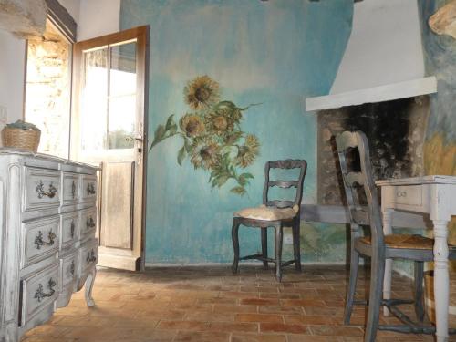 圣萨蒂南艾普特Le Jas des aiguiers的一间房间,配有椅子和墙上的绘画作品
