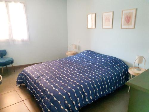 BompasAppartement plein pied climatisé dans maison catalane的卧室配有蓝色和白色的被子。