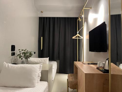 安塔利亚AG Hotels Antalya的酒店客房配有一张床和一张书桌及一台电视