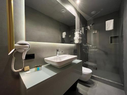 安塔利亚AG Hotels Antalya的一间带水槽和卫生间的浴室以及一部电话