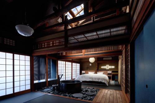 丰冈市城崎温泉 旅館 つばき乃 - Kinosaki Onsen Ryokan Tsubakino的一间卧室配有一张床和一个浴缸