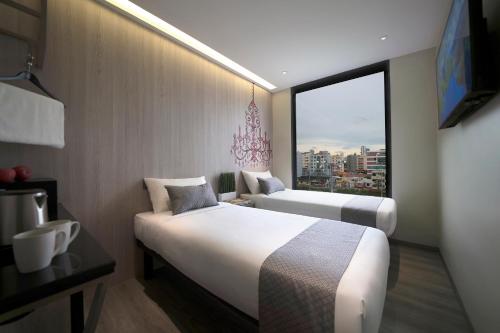 新加坡Hotel 81 Premier Princess的酒店客房设有两张床和大窗户。