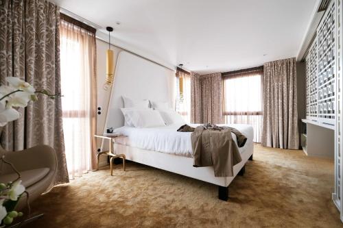奥尔良印记Spa酒店的卧室设有白色大床和窗户。