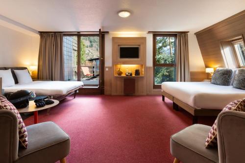 圣热尔韦莱班SOWELL HOTELS Mont Blanc et SPA的酒店客房,设有两张床和一张沙发