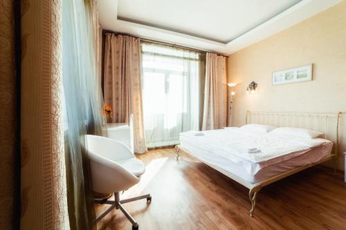 车里雅宾斯克Five Stars Comfortable Kvartira的卧室配有床、椅子和窗户。