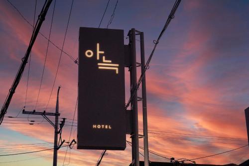 乌山市Aank Hotel Osan的日落前的柱子上的标志