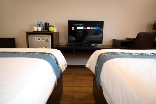 Bồ Sơn东都明月酒店Dong Do Minh Nguyet的客房设有两张床和一台平面电视。