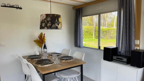 HoekPURE - Chalet Zeeland - garden out of sight的一间带桌子和白色椅子的用餐室