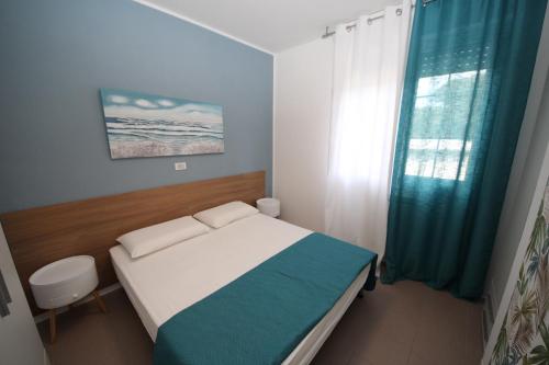 罗索利纳马雷Residence Verdena appartamento 02的一间小卧室,配有床和窗户