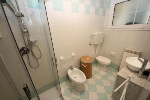 罗索利纳马雷Residence Verdena appartamento 02的带淋浴、卫生间和盥洗盆的浴室