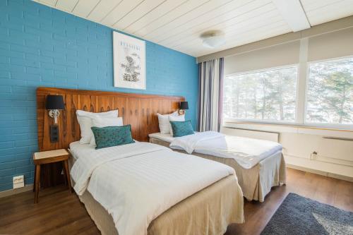 赫尔辛基兰塔普斯托酒店的蓝色墙壁客房的两张床