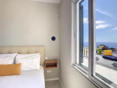 丰沙尔Avocado Villa by LovelyStay的一间卧室设有一张床和一个大窗户