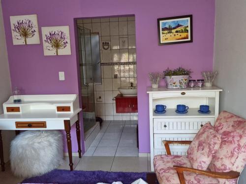 伯诺尼Victorian Villa Westdene Benoni的浴室设有紫色墙壁、水槽和椅子