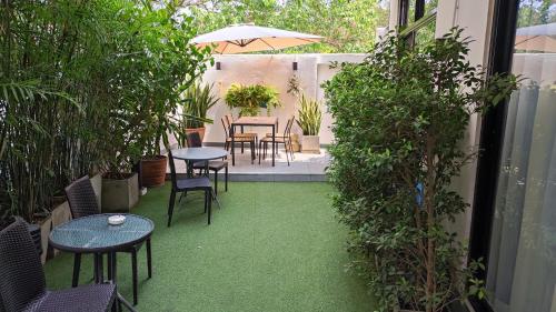 清迈蒙塔酒店的庭院配有桌椅,绿草环绕