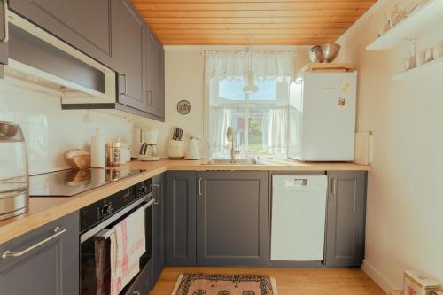 OyndarfjørðurLovely 4-BR house / Sea view / Nature的厨房配有灰色橱柜和白色冰箱