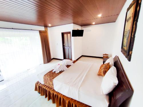 佩母德兰The Bali Menjangan Boutique Villas & Dive Center的一间卧室设有一张大床和一个大窗户