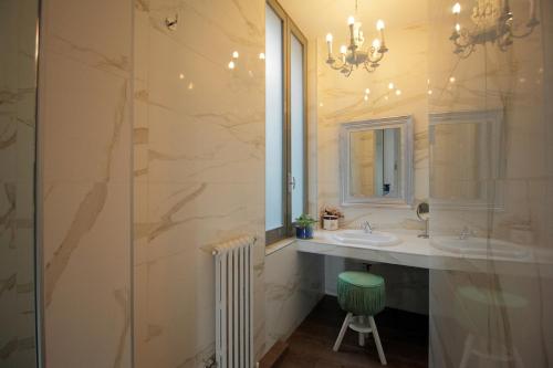 米兰安提卡洛坎达酒店的一间带两个水槽和玻璃淋浴间的浴室