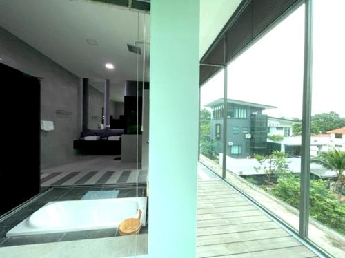 关丹Teluk Cempedak Seventh Haven的客房设有浴缸和大窗户。