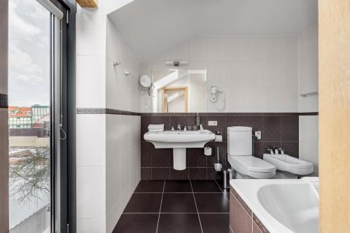 克莱佩达Euterpe Hotel的浴室设有2个卫生间、水槽和浴缸。