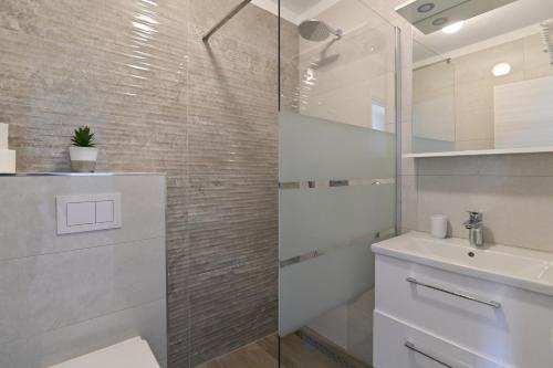 巴斯卡Rooms & Apartments Jadranka的白色的浴室设有水槽和淋浴。