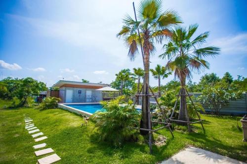 Kaeng KhoiMe and Tree Villa的一个带游泳池和棕榈树的后院