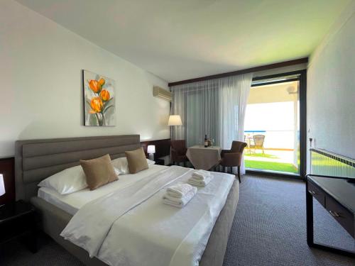 乌尔齐尼CORPUS A - Hotel Albatros的酒店客房带一张大床,带毛巾