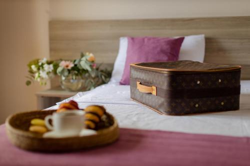 巴统黛丝日落酒店的床上的托盘食物和手提箱