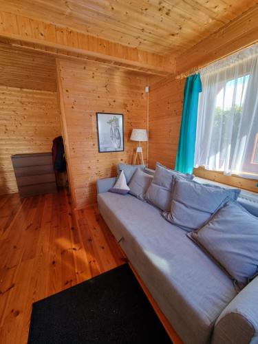 萨比诺瓦Cztery Pory Roku的一间客厅,客厅配有沙发,位于木房