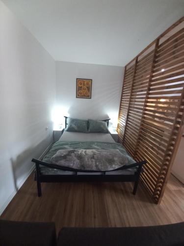 斯雷姆斯基卡尔洛夫奇Dvorska oaza的一间卧室配有一张带木制床头板的床