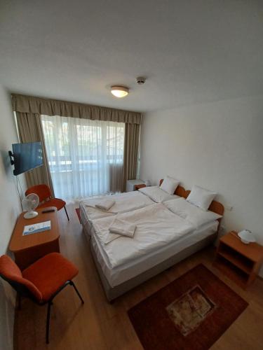 巴拉顿城堡PSZ Hotel Beach Földvár的卧室配有一张白色大床和一把椅子