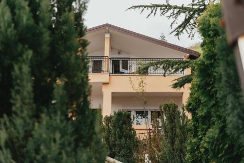 奥赫里德Villa Pandora的带阳台的房屋,前面有树木