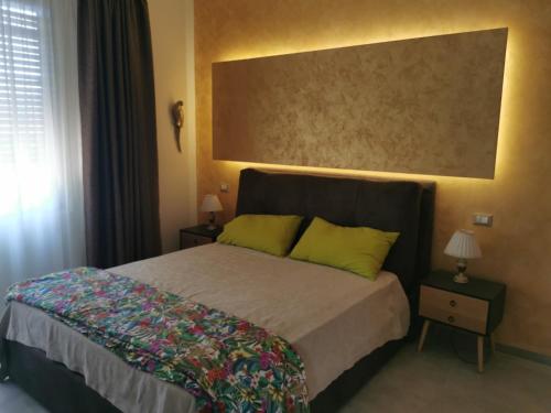 蒙特西尔瓦诺L'Anfora的一间卧室配有一张带两个绿色枕头的床